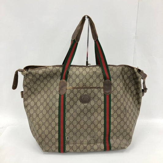 Designer handbag with patterned fabric and green and red stripes on a white background