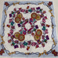 Colorful patterned fabric with decorative elements on a wooden surface